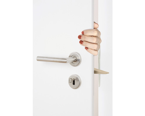 Geöffnete weiße Tür mit Edelstahl-Türgriff und Türschloss