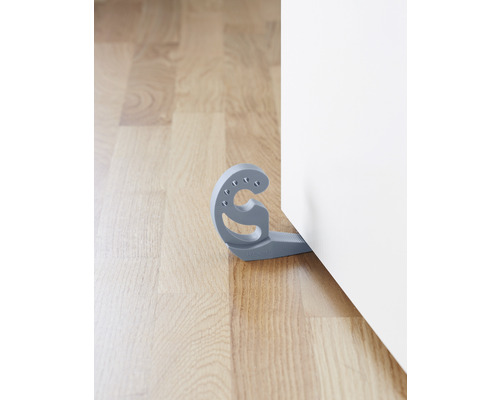 Grauer Türstopper aus Kunststoff an einer Tür auf einem Holzboden