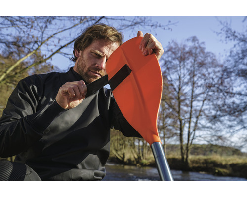 Mann befestigt Paddel am Kajak Trockenanzug für Outdoor Wassersport