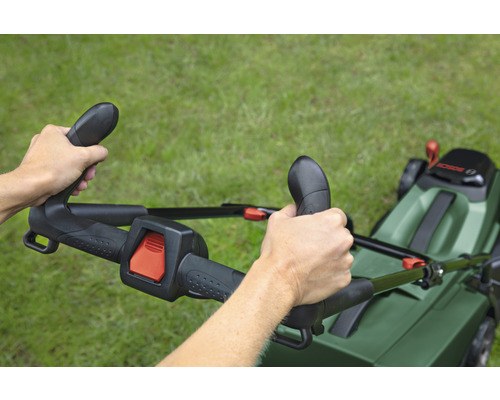 Person bedient Rasenmäher auf Rasenfläche.