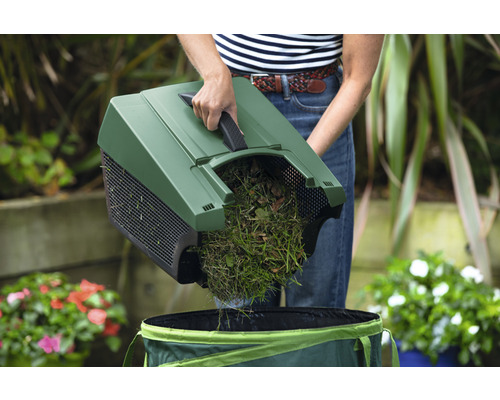 Eine Person leert einen Laubsammler in einen Gartensack