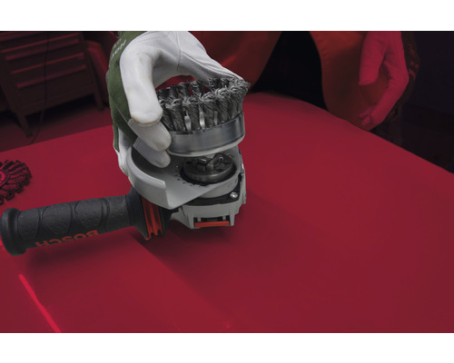 Bürstenaufsatz für Winkelschleifer wird von einer Hand gehalten