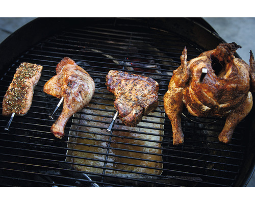 Gegrilltes: Lachs, Hähnchenkeule, Kotelett und ganzes Hähnchen auf einem Grill