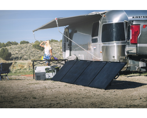 Campingplatz-Szene mit Wohnwagen, Solaranlage und Kühlbox für Outdoor-Aktivitäten