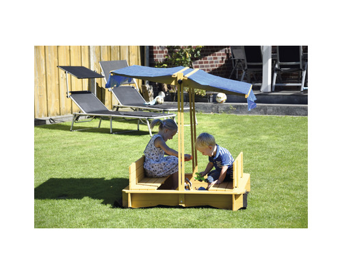 Kinder spielen in einem Sandkasten mit Sonnenschutz im Garten.