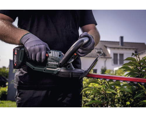 Person mit Metabo Akku Heckenschere beim Heckenschnitt