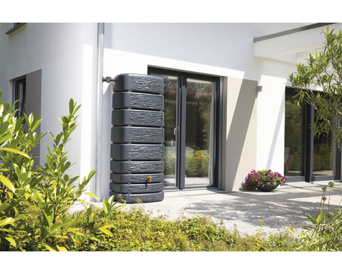 Regentonne aus Kunststoff mit Wasserhahn vor einer Hauswand