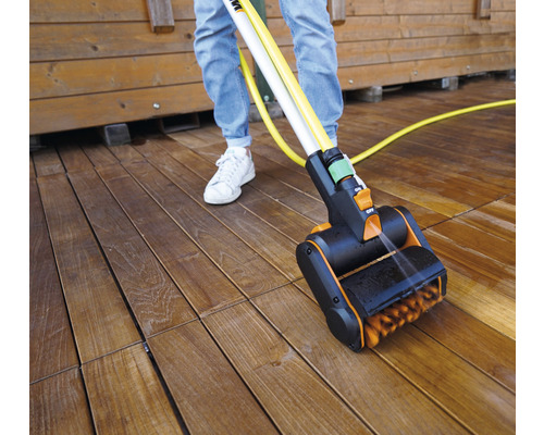 Terrassenreiniger im Einsatz auf einer Holzterrasse mit Person