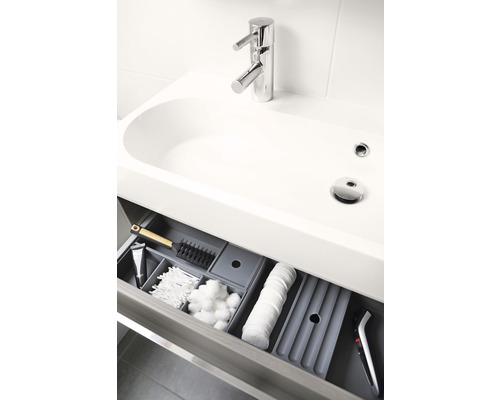 Waschbeckenunterschrank mit geöffneter Schublade und Badezimmerutensilien