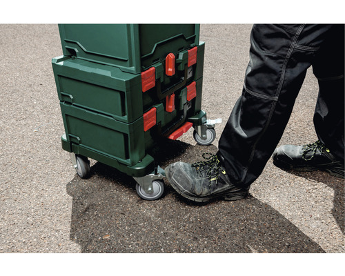 Gestapelte Werkzeugkoffer mit Rollen und Fuß auf dem Rad