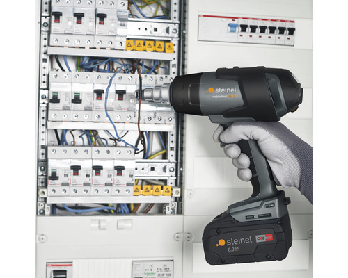 Akkubetriebenes Heissluftgebläse im Einsatz an einem Verteilerkasten.