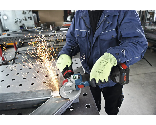 Eine Person schleift mit einem Akku-Winkelschleifer Metall, wobei Funken fliegen.