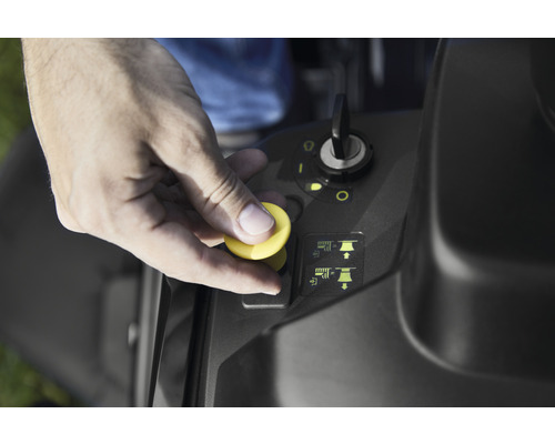 Hand betätigt Knopf am Rasentraktor