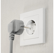 Steckdose mit eingestecktem Stecker in der Wand