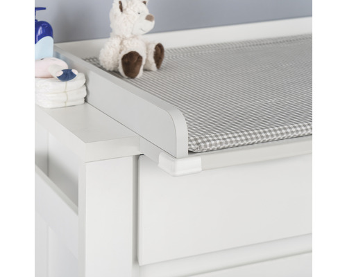 Detailaufnahme einer Wickelkommode mit Wickelauflage, Windeln und Babypflegeprodukten