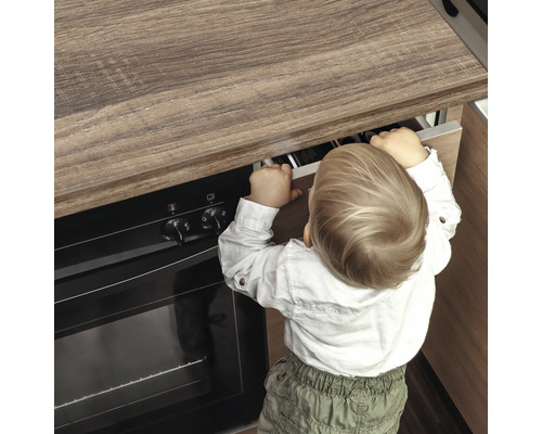 Kleinkind öffnet eine Schublade in einer Küche, potenziell als Symbol für Kindersicherheit in der Küche