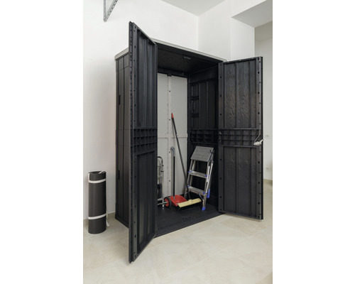 Geöffneter Geräteschrank mit Leiter und Gartengeräten