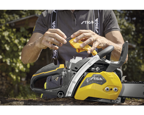 Person befüllt Motorsäge mit Öl. Stiga Logo.