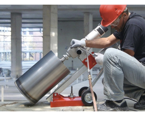 Ein Arbeiter bedient eine Kernbohrmaschine mit Ständer