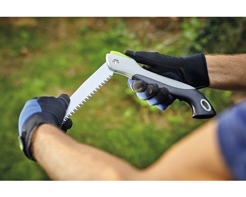 Eine Person hält eine Klappsäge mit Handschuhen.
