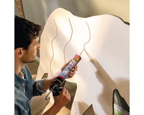 Mann verwendet Montagekleber auf einer Holzfigur.