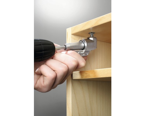 Ein Winkelvorsatz wird mit einem Akkuschrauber an einem Holzregal befestigt.