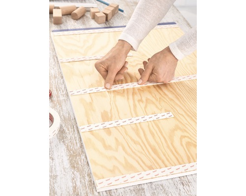 Anbringen von doppelseitigem Klebeband auf einer Holzplatte