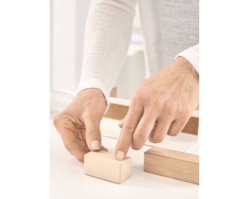 Person hantiert mit Holzbausteinen