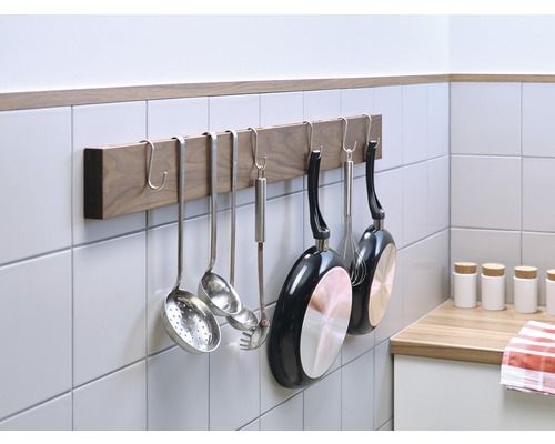 Küchenutensilien an einer Holzleiste hängend