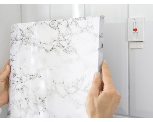 Dekorfolie mit Marmormuster wird an einer Badezimmerwand angebracht.