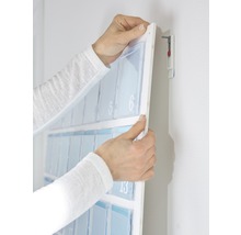 Hände montieren einen Adventskalender mit Fächern an der Wand.