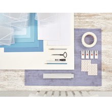Bastelmaterialien für Bilderrahmen auf einem Tisch: Bilderrahmen, Papier, Schneidewerkzeug, Kreidemarker, Bleistift, Klebeband, Bilderhaken und Klebestreifen