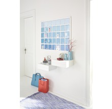 Flur mit Wandkalender, zwei weißen Regalen, blauer Tasche, roter Geschenktüte und blauem Teppich