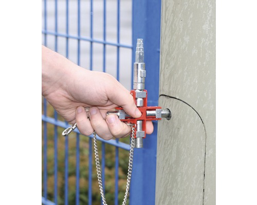 Eine Hand bedient einen Vierkantschlüssel an einem Metallpfosten