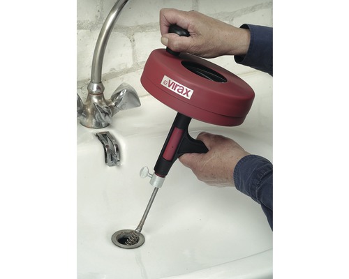 Eine Rohrreinigungsspirale von Virax wird in einem Waschbecken verwendet.