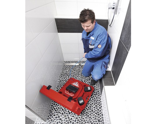 Ein Mann verwendet eine Inspektionskamera in einem Badezimmer, um Abwasserleitungen zu überprüfen.