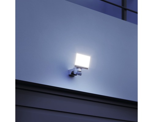 Quadratischer LED-Außenstrahler an einer Wand montiert.