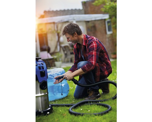 Ein Mann kniet im Garten und pumpt ein Schwimmbecken mit einem Mehrzwecksauger auf.