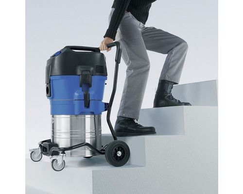 Mann transportiert Nass Trockensauger auf Treppe