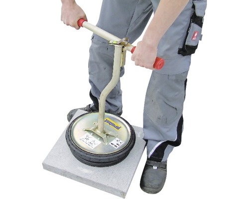 Mann verdichtet Pflastersteine mit einem Pflasterstampfer