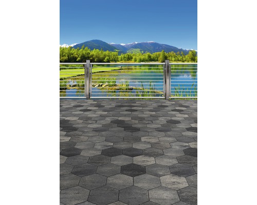 Terrasse mit sechseckigen Pflastersteinen und Edelstahlgeländer mit Blick auf einen See und Berge