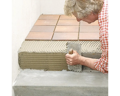 Fliesenleger bei der Arbeit, Fliesen werden auf einer Treppe verlegt.