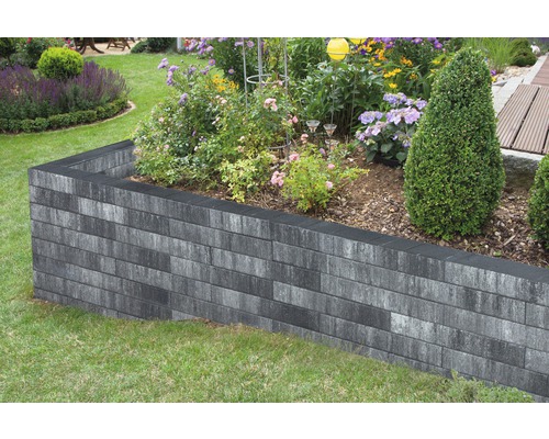 Hochbeet aus grauen Betonsteinen im Garten mit Blumen und Pflanzen