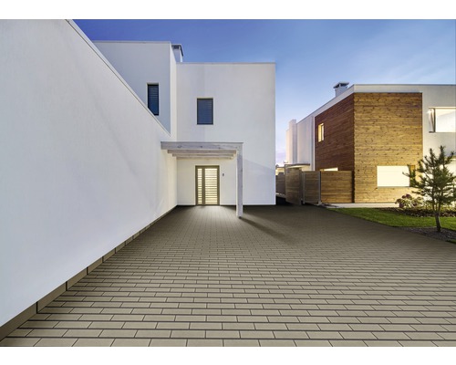 Außenbereich mit Pflastersteinen vor modernen Wohnhäusern.