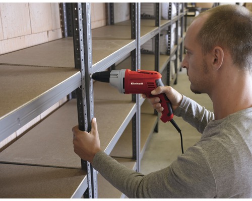Eine Person montiert ein Regal mit einem roten Einhell Bohrschrauber.