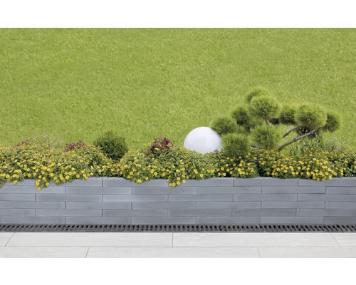 Garten mit Hochbeet aus Betonsteinen, bepflanzt mit Blumen und Ziersträuchern