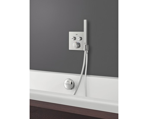 Aufputz-Badewannenarmatur mit Handbrause und Grohe Logo an einer weißen Badewanne