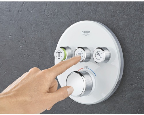 Grohe Armatur mit Hand auf Bedienknopf am Duschsystem