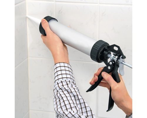 Auftragen von Dichtmasse mit einer Kartuschenpistole auf Fliesen