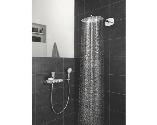 Badezimmer mit Kopfbrause und Handbrause an dunkler Wand mit Fliesen